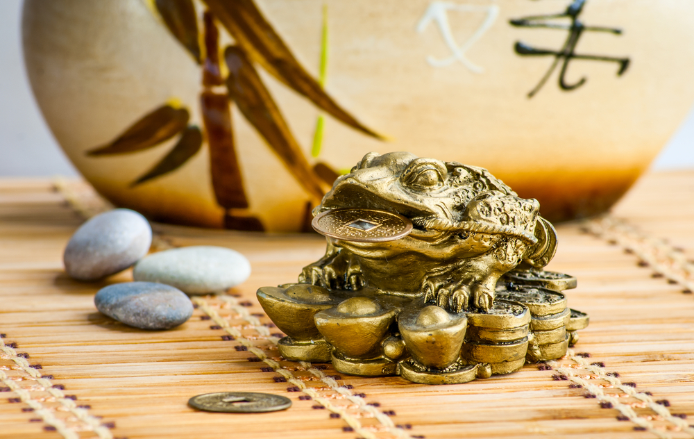 Goldene Feng Shui Froschfigur auf Bambusmatte