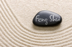 Schwarzer Stein, auf dem Feng Shiui steht auf hellem Sand